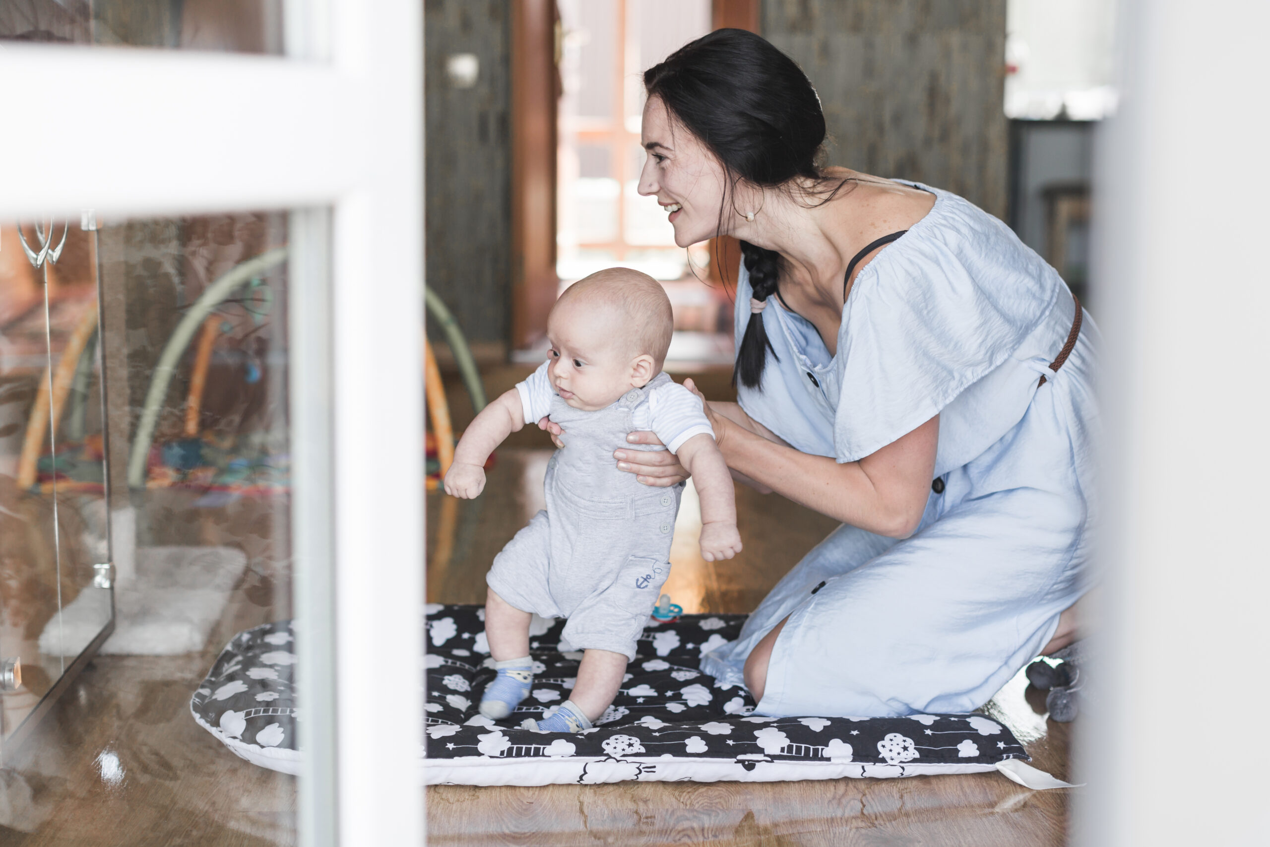smiling portrait young woman playing with her baby home