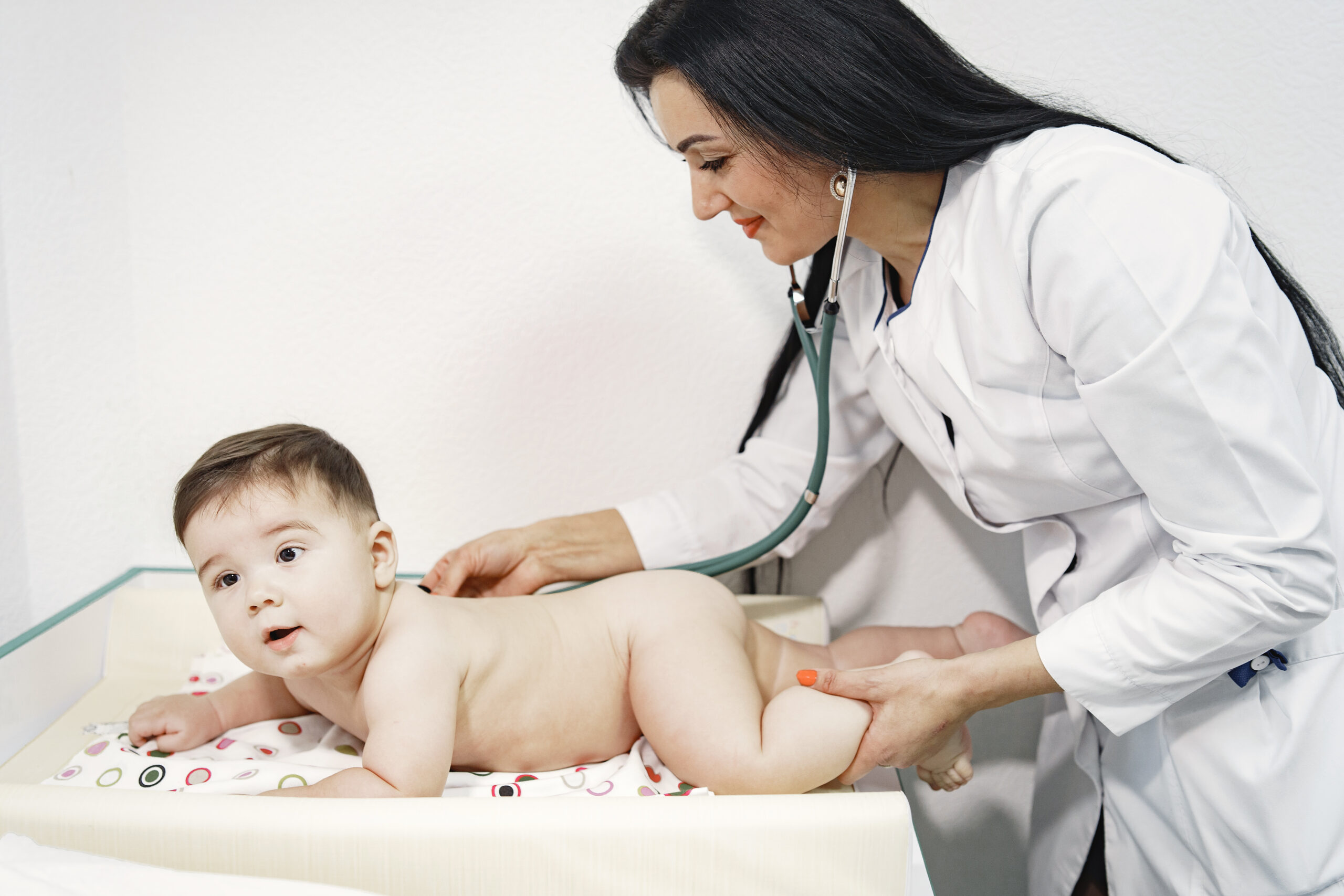 woman with stethoscope baby diaper baby lying tummy scaled.jpg